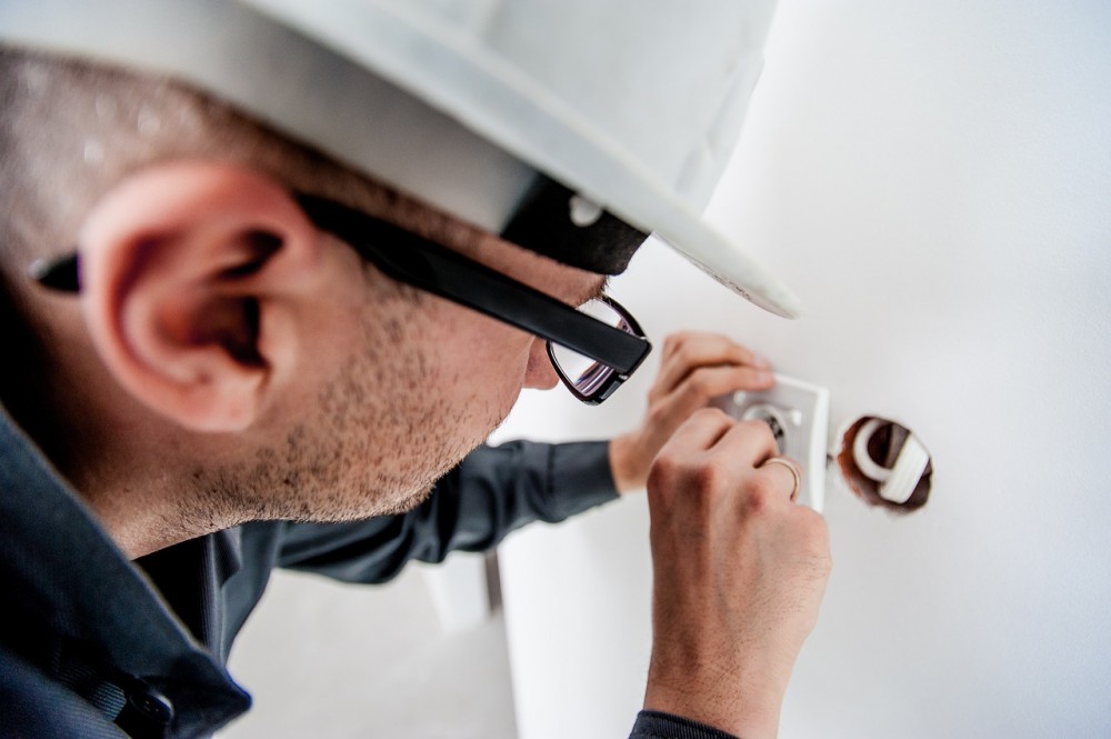 Electrician preparing outlet for construction camera installation